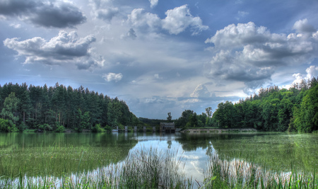 Skary clouds reflects at river near damの写真素材