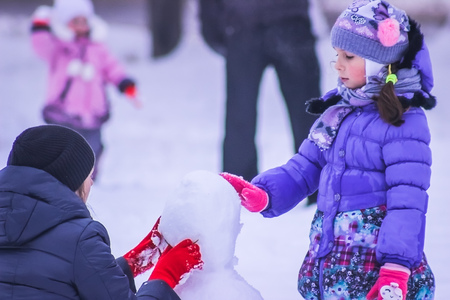 Zhytomyr, Ukraine - January 11, 2016: Parents and kids makes snowmanのeditorial素材