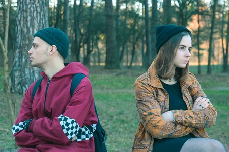 two happy homeless man and woman take offense at one another