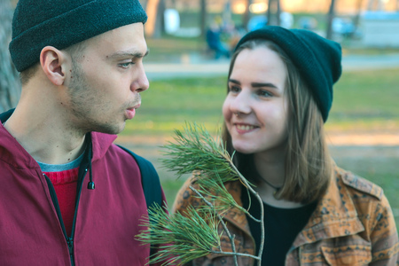 two happy homeless man and smiling woman hold pine stick in the eveningの写真素材
