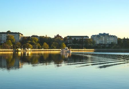swimming boat in the evening city viewの写真素材