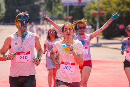 Zhytomyr, Ukraine - June 25, 2016: happy people crowd partying under colorful powder cloud at holi...