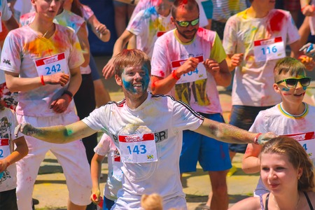Zhytomyr, Ukraine - June 25, 2016: happy people crowd partying under colorful powder cloud at holi fest, festival of colors in summer, amazing moment, then run competitionのeditorial素材