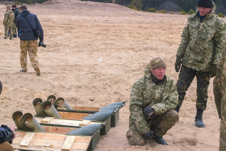 Zhytomyr, Ukraine - March 5, 2015: Soldiers at a halt clean weapons, replenish ammunition, eat,...