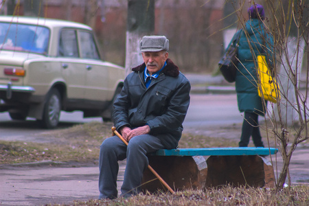 Zhytomyr, Ukraine - October 20, 2015: Man sitting on a bench with stickのeditorial素材