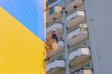 Zhytomyr, Ukraine - September 05, 2015: Roof cleaning with high pressure near ukrainian flagのeditorial素材
