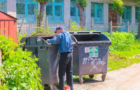 Homeles man searching food in thrash canのeditorial素材