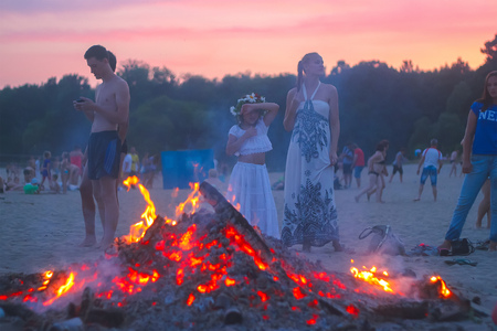 Zhytomyr, Ukraine - July 12, 2016: People celebrating in evening at the beach next to fireのeditorial素材