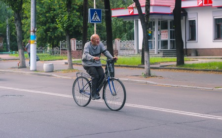 Zhytomyr, Ukraine - September 05, 2015: Senior man on cycle ride in street local countrysideのeditorial素材