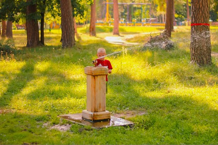 Zhytomyr, Ukraine - September 23, 2016: Young boy drinking at a water fountain at sunsetのeditorial素材