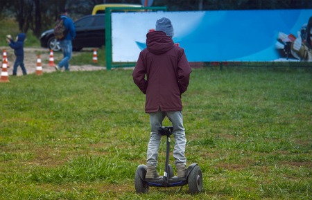boy riding on GyroScooter in park on a summer eveningの写真素材