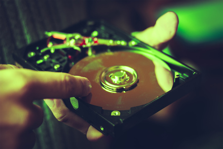 Computer hard drives being recycled at green background. Man pointing at disksの写真素材