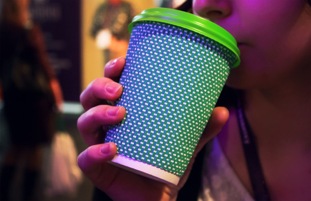 girl hands holding plastic cup of coffee and drinking. Christmas backgroundの写真素材