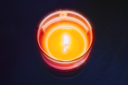 burning candle on the table, purple background