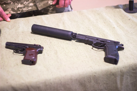 weapons, two pistols, one with a silencer