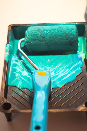 roller for wall painting in green paintの写真素材