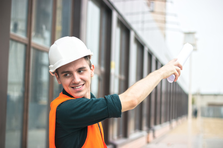 Young business man at construction business plans to make their work more efficient.. Warm orange light.の写真素材