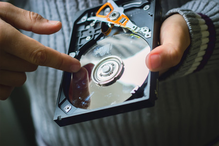 Hands hold the hard drive from the computerの写真素材