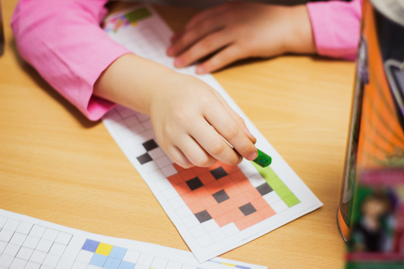 Young girl paint coloring paper on the tableの写真素材