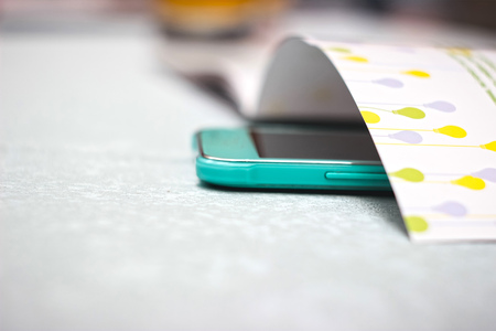 Magazine on the table and green smartphoneの写真素材