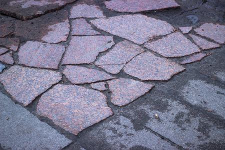 Stone pavement texture. Granite cobblestoned background at evening. Broken asphaltの写真素材