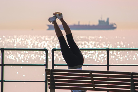 Girl doing a plank on exercise at front of the sea