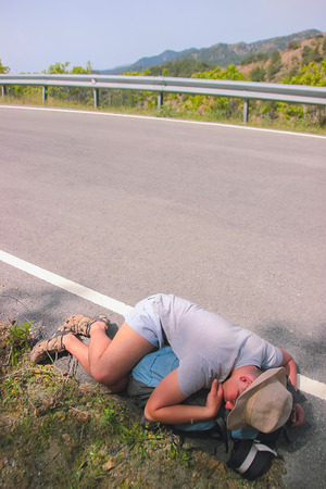 Drunk Man Sleeps on the edge of highwayの写真素材