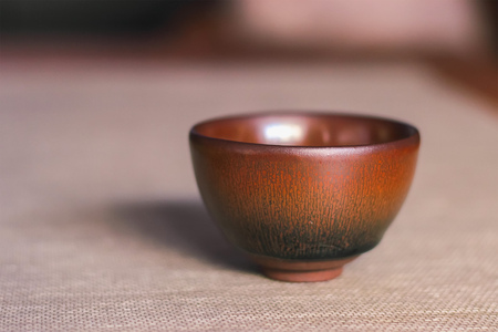 Handmade empty pottery tea bowl brown in handsの写真素材