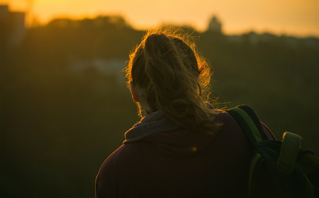 Silhouette of a girl taking pictures of the sunriseの写真素材