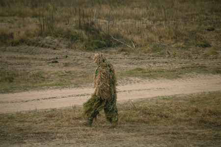 Soldier in camouflaged sniper suit searching for the positionの写真素材