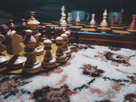Wood chess piece on chessboard with Blurred image and vintage color tone night process