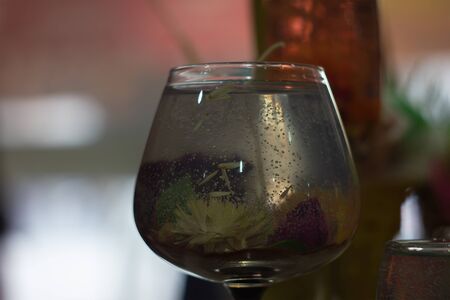 frozen rose in water and ice at glass cup with restaurant backgroundの写真素材