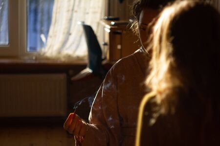 Smudging ceremony using Peruvian Palo Santo holy wood incense stick at interior homeの写真素材