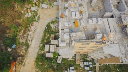 Aerial View of Building Process at the Construction Site. Engineers crane and city suburbs.