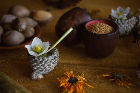 Composition of flax, sesame and avocado seeds in banks at yellow flowers background