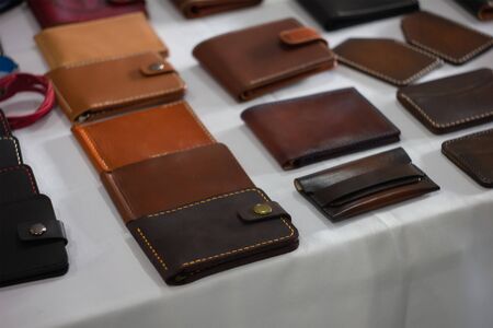 Set of hand made leather man wallet. Leather craft. On table background