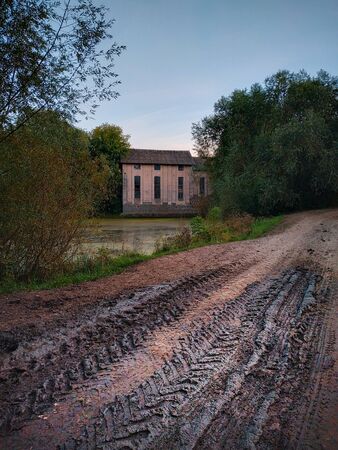 Wheel ruts on the dirt road. Mill at background