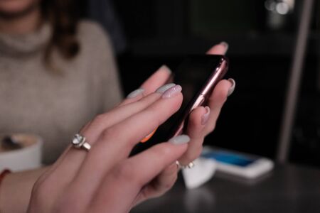 Close up of woman hands writing text message on her cell phone, enjoying online communication, typing feedback. Technology conceptの写真素材