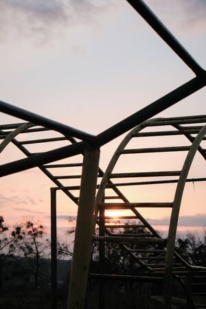 metal playground with bars and stairs close-up against the background of sunsetの写真素材