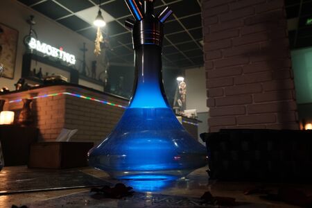 hookahs on the table with smoke and red and blue light in the lounge cafe. Concept of traditional...