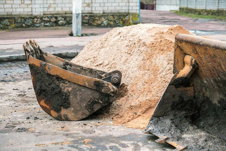 Backhoe basket working at the sand background.