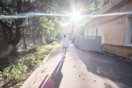 Girl searching ripe apricots under the apricot tree in the summer town.
