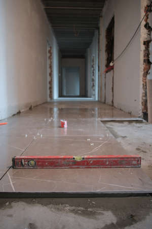 Dirty bubble level tool is checking cement wall horizontal closeup in construction site.の写真素材