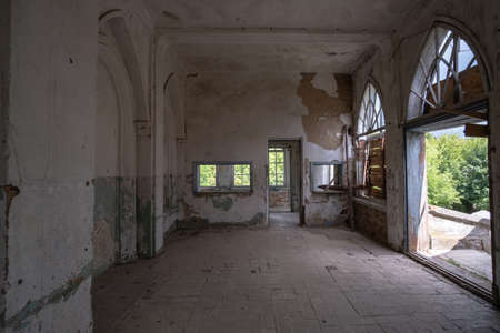 Inside abandoned house. View on broken window with curtain. Grunge scene.の写真素材