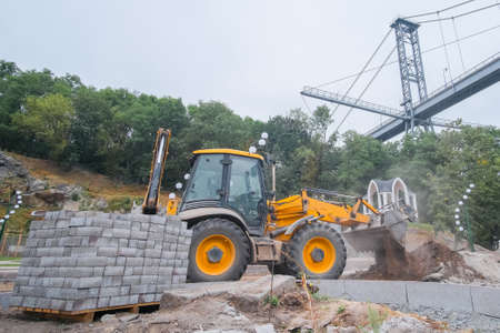 Excavator at reconstruction coastal structures, construction of quay at small townの写真素材