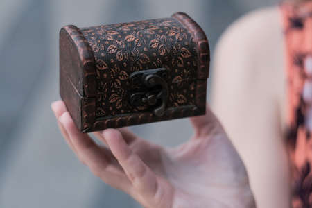 Closed wooden chest on the girl hands.の写真素材