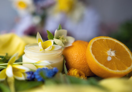 A jar of cosmetic cream and an orange cut in half. Natural cosmetic.の写真素材