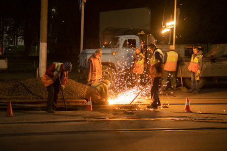Zhytomyr, Ukraine - May 12, 2021: Maintenance works at the tram line. Workers weld tram railway.のeditorial素材
