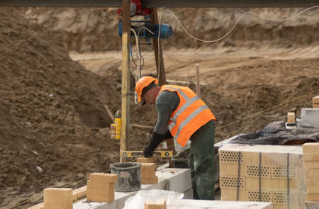 Zhytomyr, Ukraine - September 8, 2020: Workers laying bricks on construction site.のeditorial素材