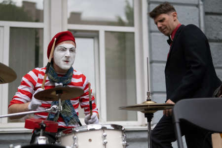 Zhytomyr, Ukraine - May 15, 2021: Professional mime artist performing different emotions and interacts with people. Man playing rock on drumsのeditorial素材